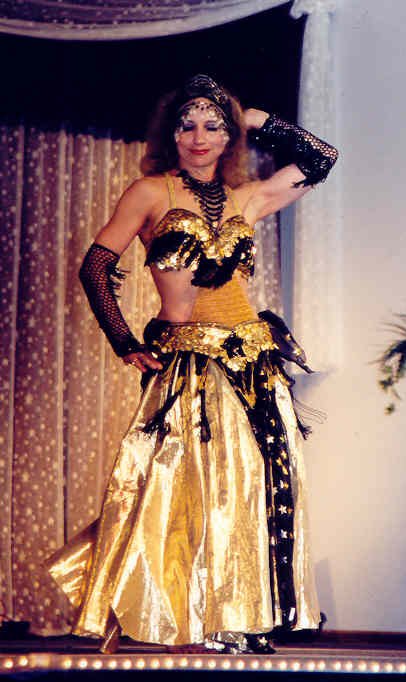 Ashera performs in gold and black costume