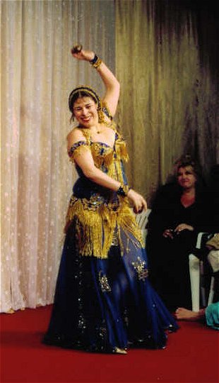 dancer smiles while performing with zills wearing dark blue with gold accents