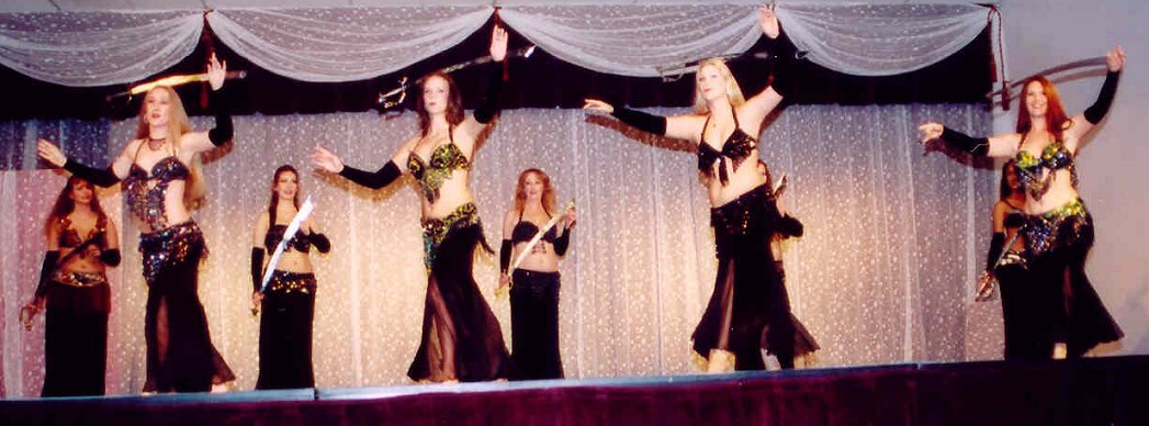 large group of dancers wearing black performing with swords