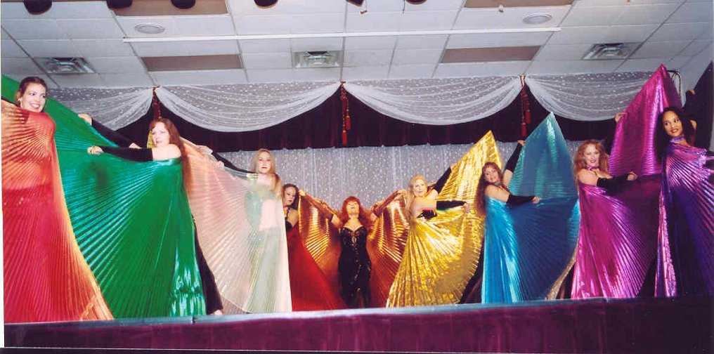 dancers with multicolored wings pose on stage