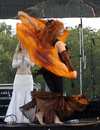 Isis on stage performing with copper colored sheer veil