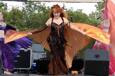 Isis on stage performing with copper colored wings