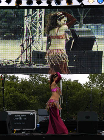 Marjan in dark pink dances on stage and is also shown on big screen