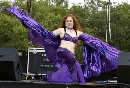 Rachael wearing purple performs with pleated lame wings