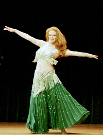 dancer Nezrana performs wearing a green skirt with silver bedla