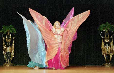 3 dancers back to back perform with outstretched wings