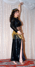 dancer with dark hair in black sequined costume