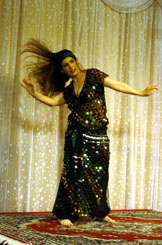 dancer wearing a dark dress with sequins swings hair