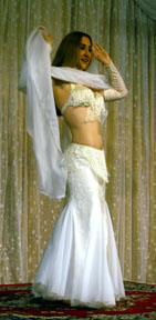 dancer in all white performs with veil on stage