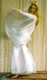 dancer in all white performs with veil on stage