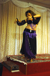 dancer in purple costume with headback performs on stage
