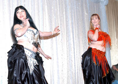 2 dancers wearing black skirts performing