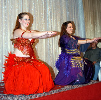 dancers wearing red and purple perform on stage