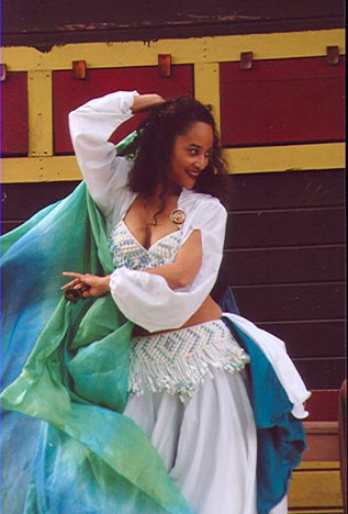 Marjan in white costume performs with a blue and green veil