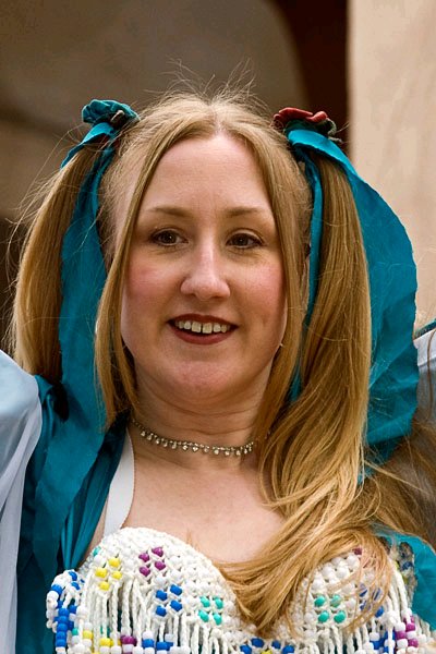 close-up of dancer wearing teal and white with ribbons tied in her hair during a performance