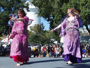 2 dancers wearing pink and purple perform with canes