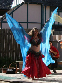dancer wearing red dances on stage using a turquoise veil