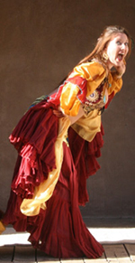 dancer wearing orange expressively poses on stage