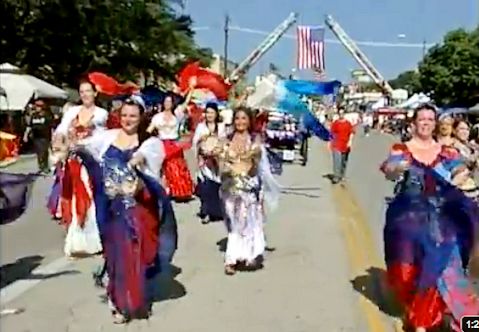 dancers wearing red, white, and blue participate in the Arlington 4th of July Parade in 2012