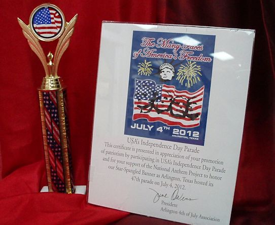 image of a certificate and trophy from the Arlington 4th of July Association on a background of red fabric