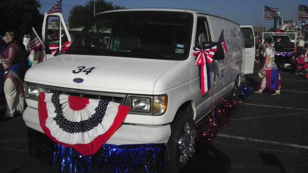 image of a white van with red, white, and blue decorations preparing for the parade