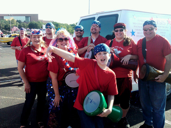 a group of drummers wearing red, white, and blue poses for a photo while waiting for the parade to begin
